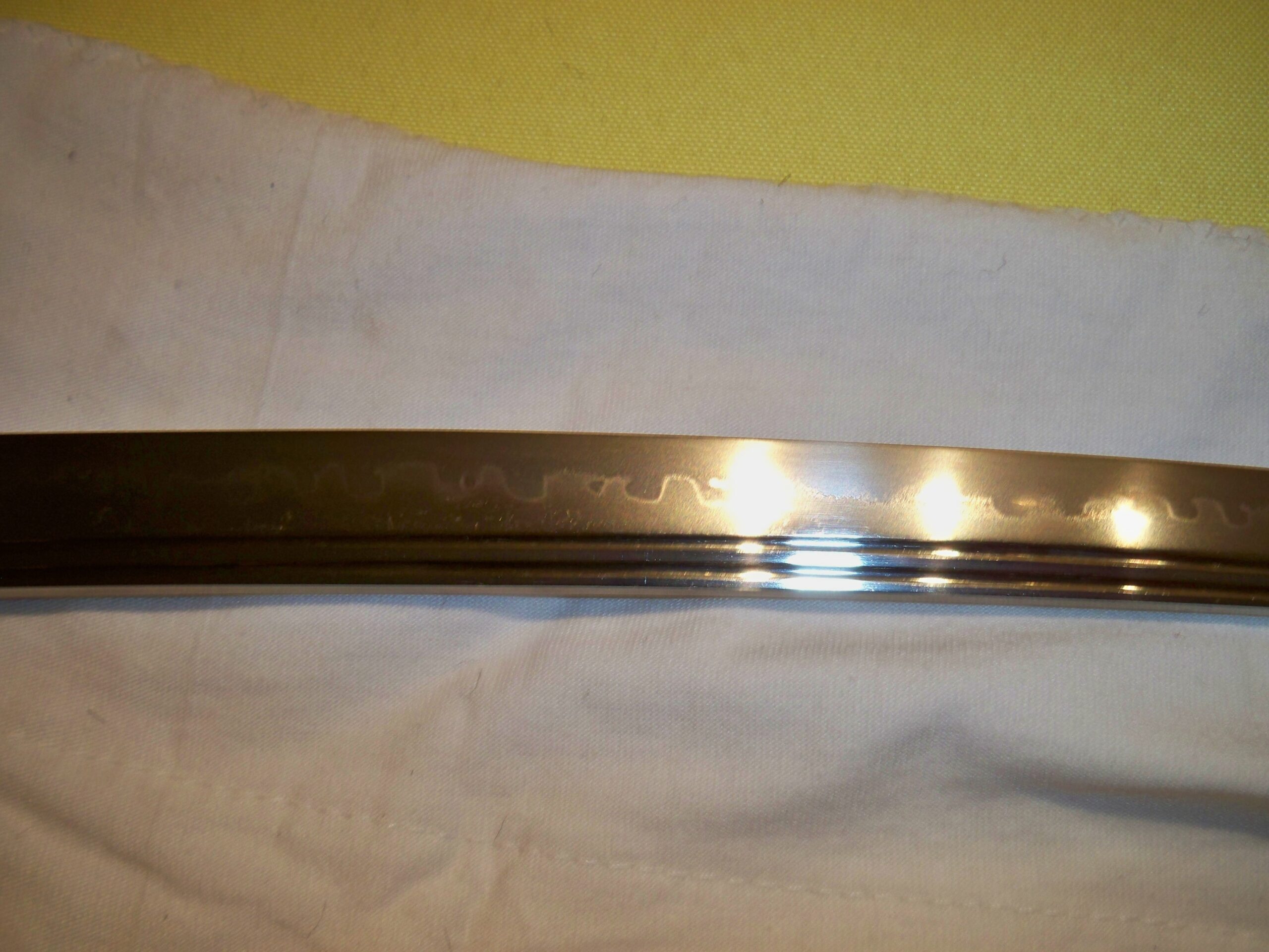 Nahaufnahme einer Katana-Klinge mit der markanten Hamon-Härtelinie und Bo-Hi-Rille